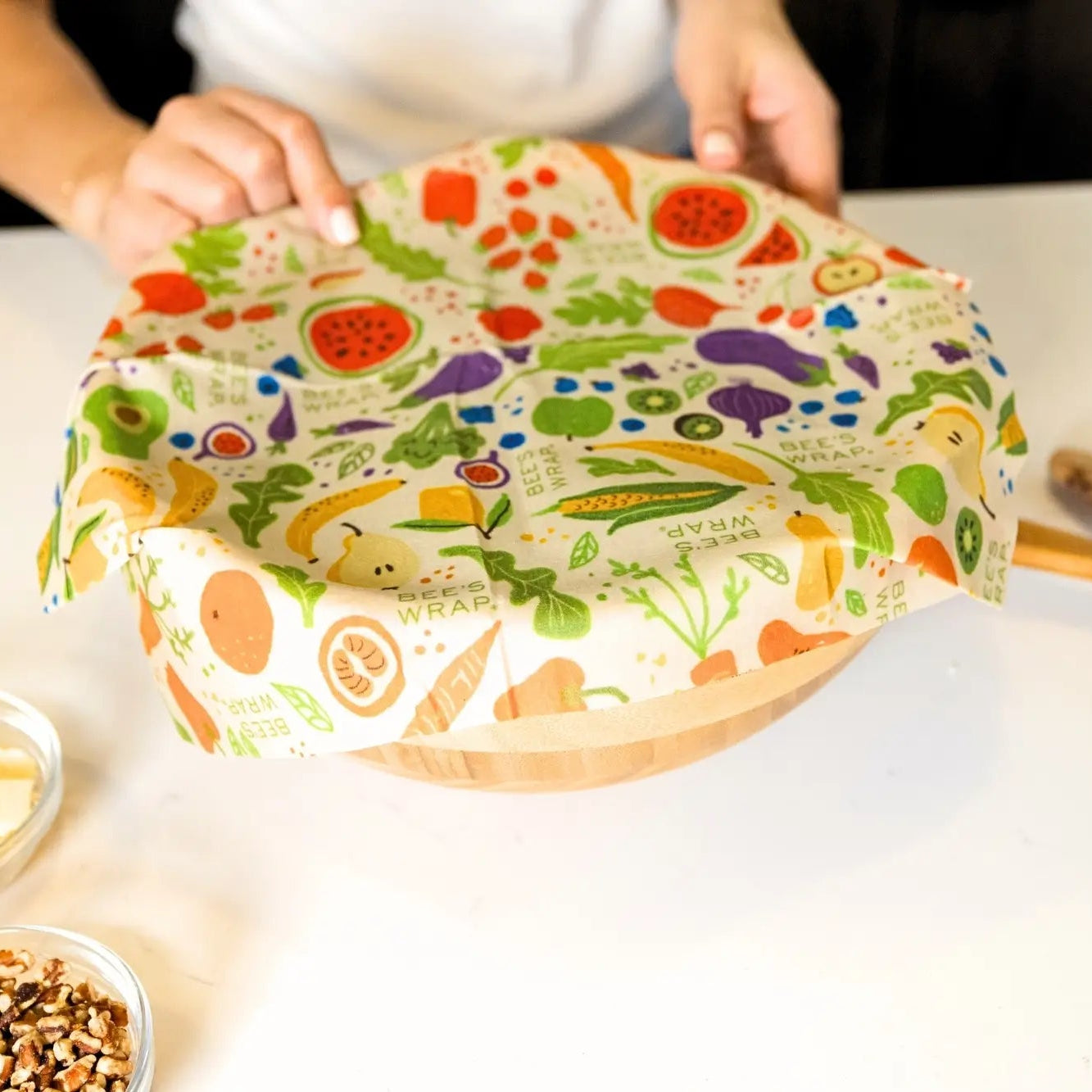 Colorful beeswax wrap with food illustrations on a white surface
