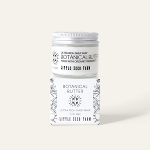 Jar of botanical butter with a white label on a light gray background