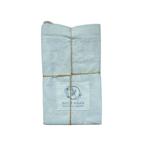 Folded light blue beeswax wrap with a brand logo on a white background