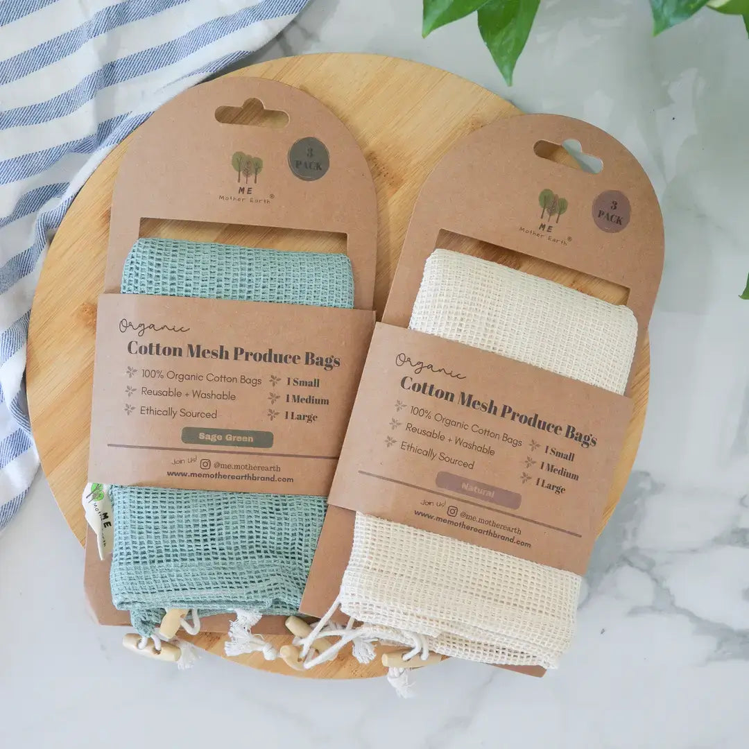 Two organic cotton mesh produce bags on packaging with a wooden board and striped fabric background.