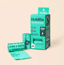 Green packaging of HoldOn certified home compostable dog poop bags with a beige background