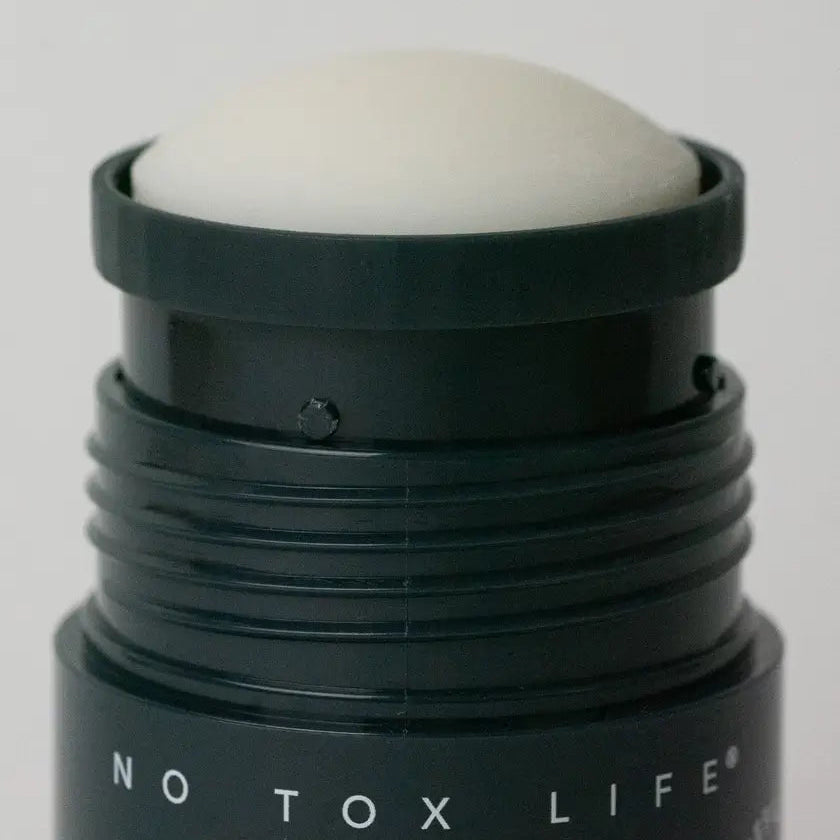 Black Earl Grey deodorant roller with white ball on top labeled 'NO TOX LIFE' against a gray background