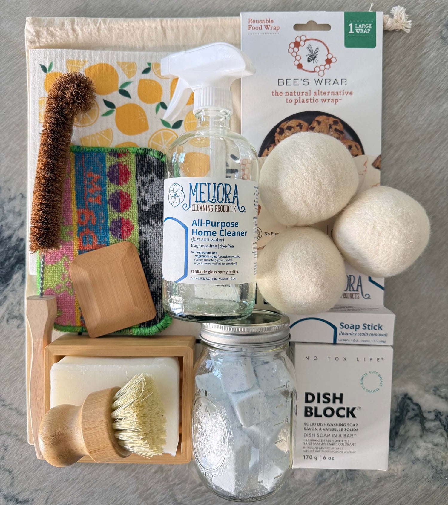 Collection of zero-waste cleaning and kitchen products on a gray surface