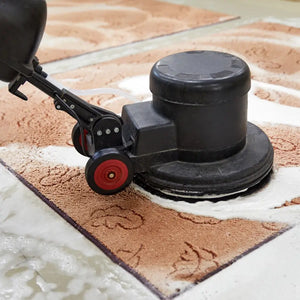 Professional floor cleaner on a carpeted floor with visible suds