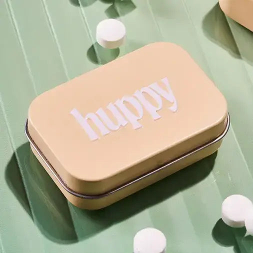 Small beige box with 'huppy' text on a green surface