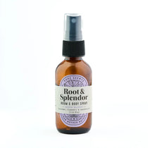 An amber glass room and body spray bottle with a black spray cap and a cream label reading 'Root & Splendor' on a white background.