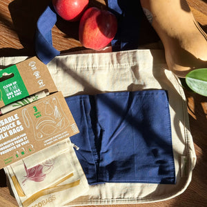 Reusable produce bags with apples on a wooden surface, featuring eco-friendly packaging.