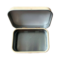 Open metal tin on a wooden surface