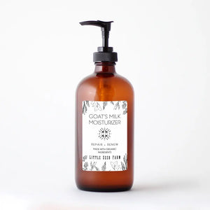 Amber bottle of goat's milk moisturizer with pump on a white background