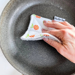 Hand using a cloth with branding to clean a pan
