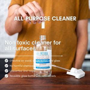 All-purpose cleaner bottle with refill tablets on a wooden surface, labeled as non-toxic and effective on various surfaces.