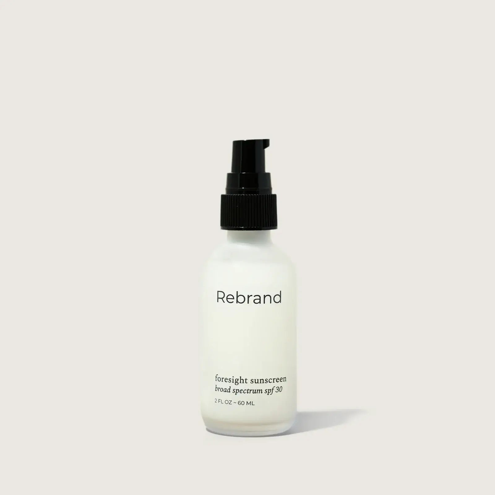 Sunscreen bottle labeled 'Rebrand' on a light gray background