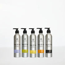 Five aluminum bottles of soap and suds on a white background.