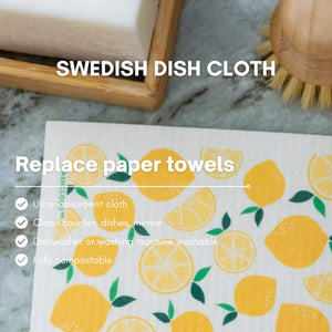 Swedish dish cloth with lemon pattern on a marble surface with cleaning tools.