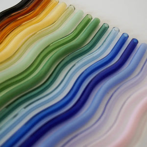 Colorful glass straws with wavy pattern on a white background