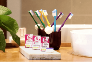 A selection of toothbrushes with replaceable heads in various colors displayed in a bathroom setting, with packaging that indicates different bristle types.